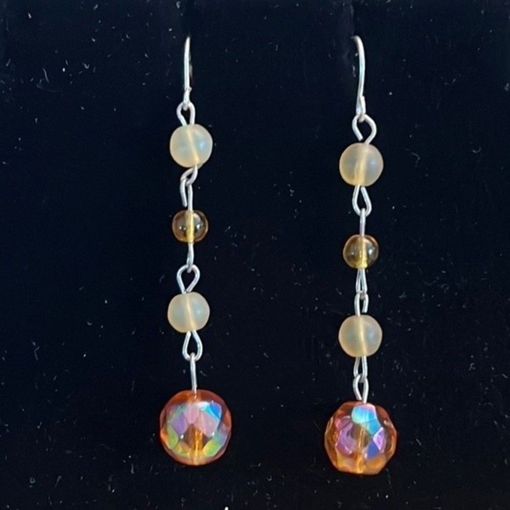 Handcrafted silver tone earrings with amber colored beads.